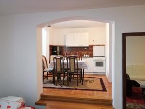 a dining room and kitchen with a table and chairs at Pansion Velickovic in Niška Banja