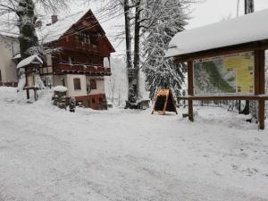 a snow covered yard in front of a building at Villa Hubertus in Srebrna Góra