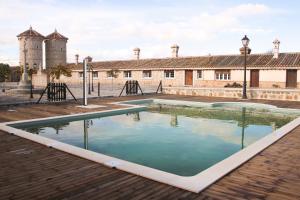 a pool of water in front of a building at Casas rurales Puente Romano in Sonseca
