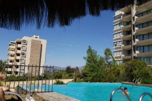 a swimming pool in front of a building at Espectacular Departamento Marina Golf Rapel in Las Cabras