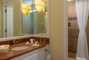 a bathroom with a sink, mirror, and bathtub at Pueblo Bonito Rose Resort & Spa - All Inclusive in Cabo San Lucas