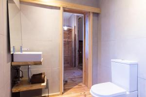 La salle de bains est pourvue de toilettes blanches et d'un lavabo. dans l'établissement Feel at Home Guest House, à Ovar