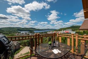 a balcony with a table and a view of a city at L'Altitude by Rendez-Vous Mont-Tremblant in Mont-Tremblant