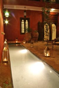 a swimming pool with lights and candles in a room at Riad Honey in Marrakesh
