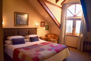 um quarto com uma cama e uma janela grande em Hotel & Apart Hotel Monte Verde em Pucón
