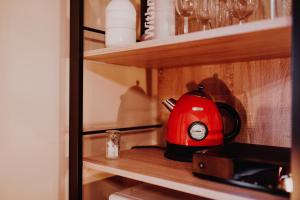 a red tea kettle sitting on a shelf at At Home - Jacuzzi privatif in Gesves