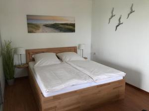 a bedroom with a bed with white sheets at Steiner Strandappartements Appartement 201 Seeseite in Stein