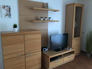a living room with a tv and a wooden cabinet at Steiner Strandappartements Appartement 201 Seeseite in Stein