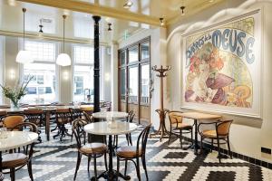 een restaurant met tafels en stoelen en een schilderij aan de muur bij Boutique Hotel Mauritz, a member of QL Hotels in Willemstad