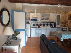 eine Küche mit einem Sofa und einem Tisch in einem Zimmer in der Unterkunft Gîte Moulin de Ludièras in Busserolles
