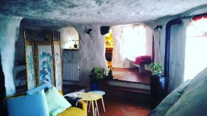 ein Wohnzimmer mit einem gelben Sofa und einem Tisch in der Unterkunft Casa Sulla Rupe in Calcata