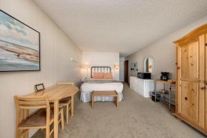 een slaapkamer met een bed, een tafel en een bureau bij Pacific Sands Resort in Neskowin