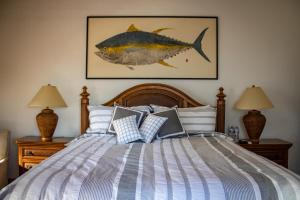 a bedroom with a bed with a fish painting on the wall at La Marina Inn in San José del Cabo