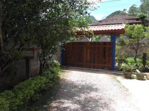 a house with a wooden gate and a driveway at Blue House in Lumiar