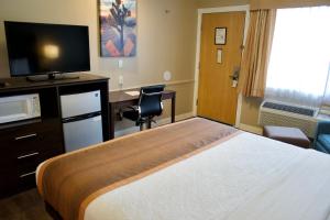 a hotel room with a bed and a desk at Best Western China Lake Inn in Ridgecrest