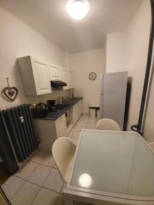La cuisine est équipée d'une table, de chaises et d'un réfrigérateur. dans l'établissement Appartement Strasbourg Cathédrale, à Strasbourg