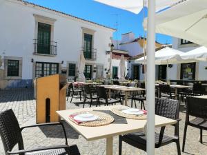 an outdoor patio with tables and chairs and umbrellas at The Portuguese Element in Faro
