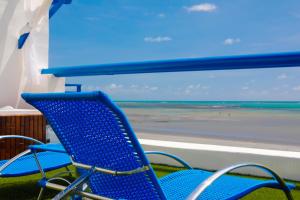 a blue chair sitting in front of a window with the ocean at Sollaris Ecopousada in Japaratinga