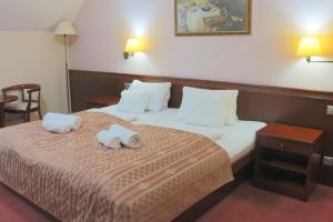 a hotel room with a bed with towels on it at Komorni Hurka in Cheb