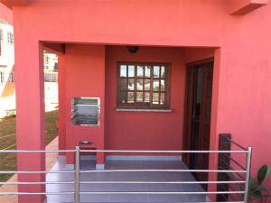 ein rotes Haus mit einer Treppe, die zu einer Tür führt in der Unterkunft Pousada Vila da Lagoa in Ubatuba