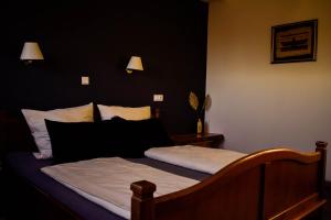 a bedroom with a bed with white sheets and black walls at Hostel Mornar in Velika Kladuša