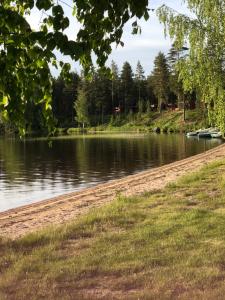 a body of water with a dirt road next to it at Joutiaisentie H 44 Sunset apartment in Joutsa