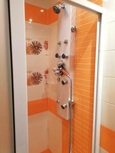 y baño con ducha y azulejos de color naranja y blanco. en Kapana Comfy 2BR Apartment in Top Center, en Plovdiv