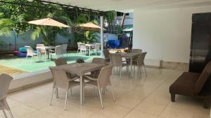 ein Restaurant mit Tischen und Stühlen und einem Pool in der Unterkunft Hostal Familiar Carmencita in Panama-Stadt