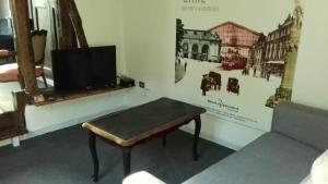 Zimmer mit einem Tisch und einem TV an der Wand in der Unterkunft Duplex La Maisonnette 1 chambre - parking gratuit in Troyes