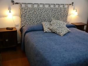 a bedroom with a blue bed with two pillows on it at Agriturismo Le Stiacce in Saturnia