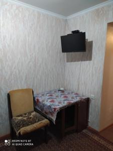 um quarto com uma mesa, uma cadeira e uma televisão em HOME em Chisinau
