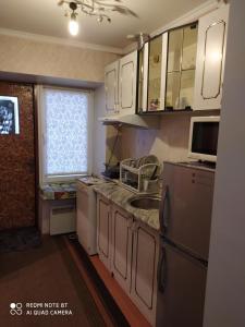uma cozinha com armários brancos, um lavatório e um micro-ondas em HOME em Chisinau