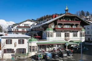 a large building with cars parked in front of it at Sporthotel Igls in Innsbruck
