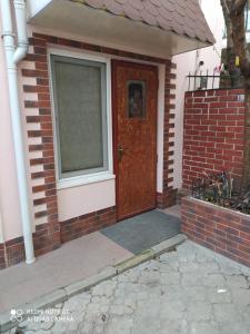 uma casa de tijolos com uma porta castanha e uma janela em HOME em Chisinau