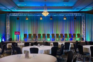 a room with tables and chairs in front of a stage at Crowne Plaza Hotel Portland-Downtown Convention Center, an IHG Hotel in Portland