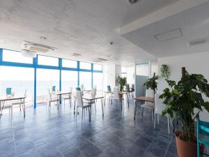 a dining room with tables and chairs and the ocean at Mykonos Resort Miura / Vacation STAY 72794 in Yokosuka