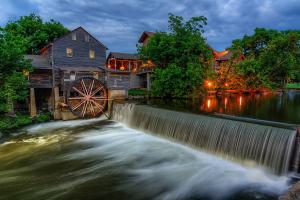 a river with a mill and a waterwheel at Mosey Bear, Hot Tub, WIFI, 685 FREE tickets each paid day!!! in Sevierville