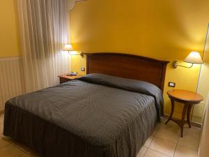 a bedroom with a bed and a table and two lamps at Locanda La Comacina in Comacchio