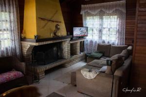 uma sala de estar com um sofá e uma lareira em LINDA CASA DE CAMPO em Viamão
