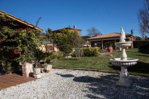 a stone fountain in the yard of a house at Casa Bella con piscina in Caldes de Montbui