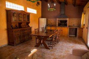 a kitchen with a wooden table and a refrigerator at Casa Bella con piscina in Caldes de Montbui