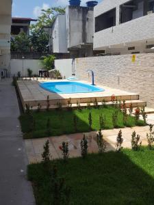 a swimming pool in a yard next to a building at Porto de Galinhas - Flat 6 - Residencial Lagoa de Porto in Porto De Galinhas