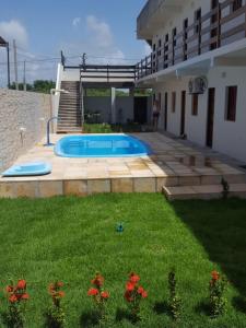 a backyard with a swimming pool and a house at Porto de Galinhas - Flat 6 - Residencial Lagoa de Porto in Porto De Galinhas