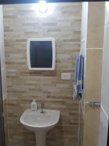 a bathroom with a sink and a tv on the wall at Porto de Galinhas - Flat 6 - Residencial Lagoa de Porto in Porto De Galinhas