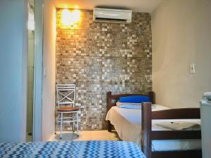 a bedroom with two beds and a brick wall at DOM POUSADA in São Gonçalo do Amarante