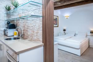 a kitchen with a sink and a brick wall at Valletta Main Street Apartment DELUXE in Valletta