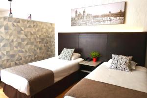 Habitación de hotel con 2 camas y una foto en la pared en Suites Havre, en Ciudad de México