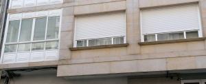 a building with windows and white blinds on it at APARTAMENTO BOLBORETA in Pontevedra