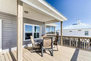 a patio with a table and chairs on a deck at Sassy Seagull in Dauphin Island