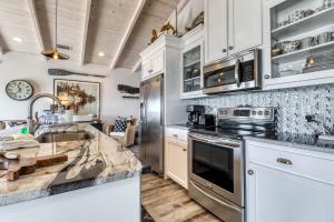 a kitchen with white cabinets and stainless steel appliances at Sassy Seagull in Dauphin Island